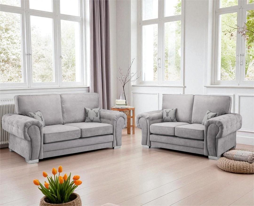Gray sofa set in a bright living room with large windows and a small table.
