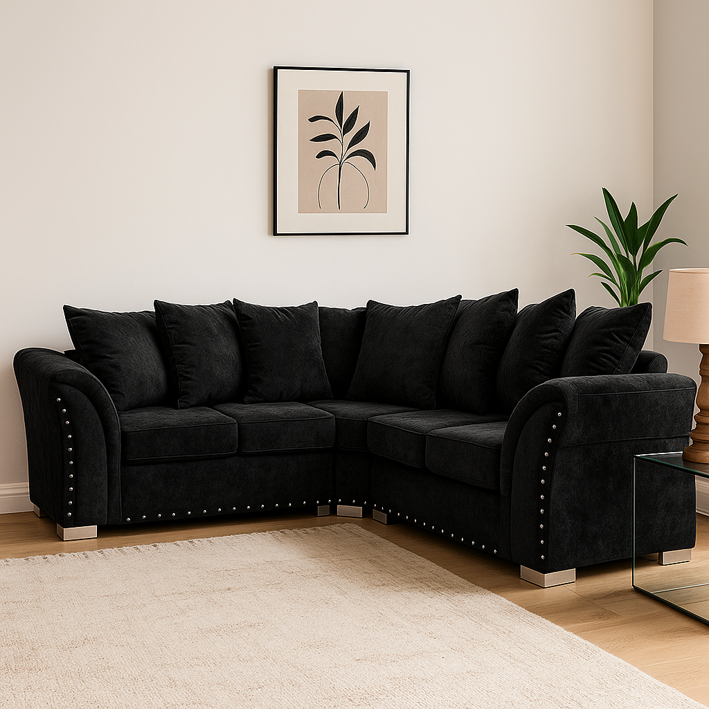 Black sectional sofa in a living room with a plant and framed picture on the wall.