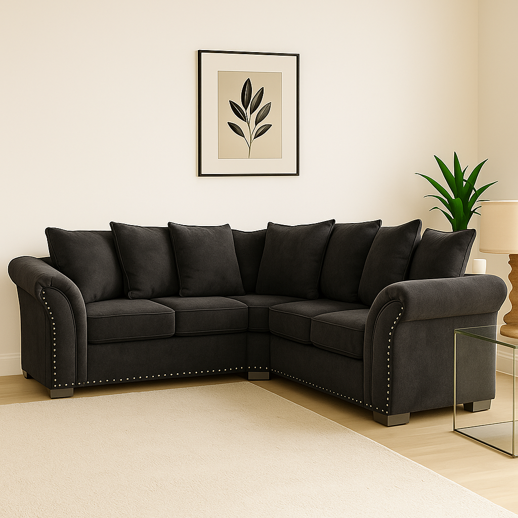 Black sectional sofa in a living room with a plant and framed picture on the wall.