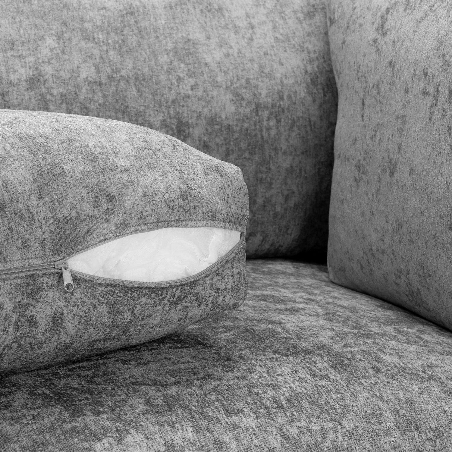 Gray textured sofa with a cushion featuring a zipper