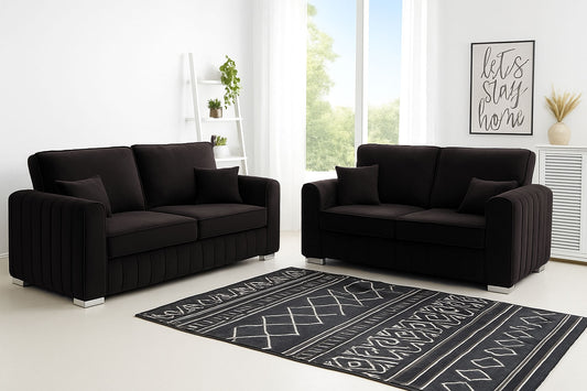 Black sofa set in a modern living room with a decorative rug.